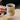 Person holding a mug of coffee from 'The Grounds Roastery' with a blurred background